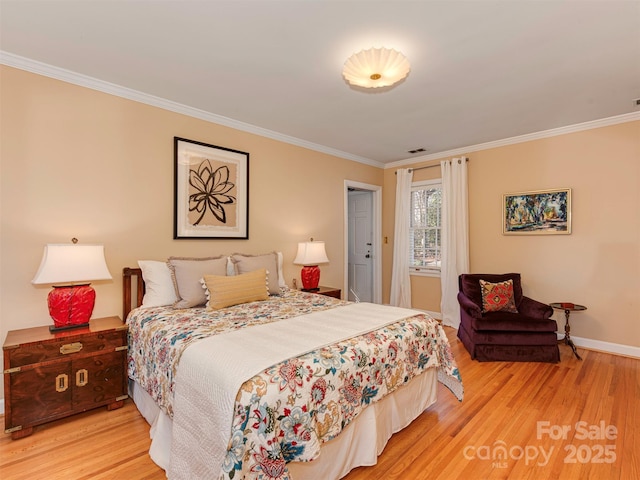 bedroom with crown molding, baseboards, visible vents, and light wood-style floors