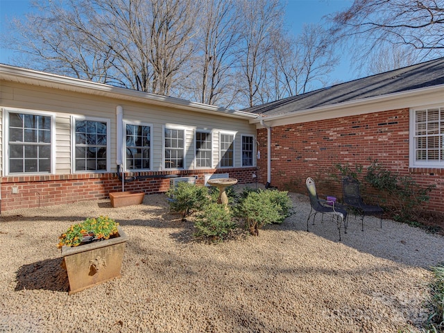 property entrance featuring a patio and brick siding