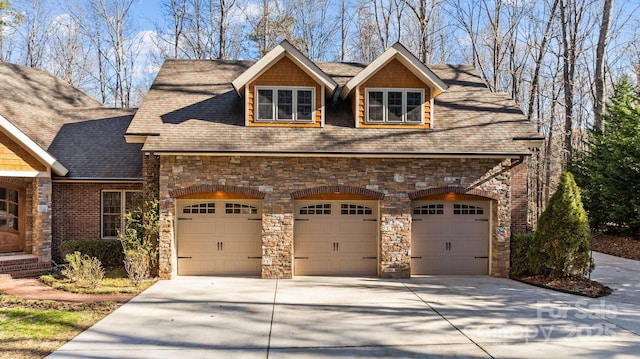 view of front of property featuring concrete driveway and roof with shingles