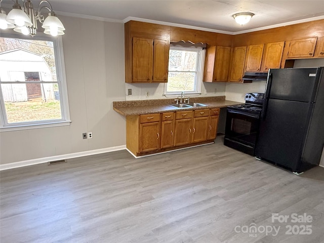 kitchen featuring pendant lighting, black appliances, and brown cabinets