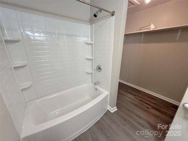 full bath with tub / shower combination, wood finished floors, and baseboards