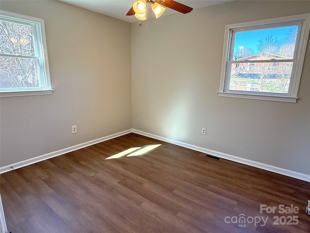 spare room with visible vents, baseboards, ceiling fan, and wood finished floors