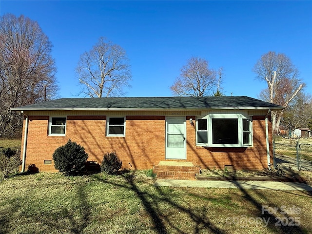 rear view of property featuring entry steps, crawl space, a lawn, and brick siding