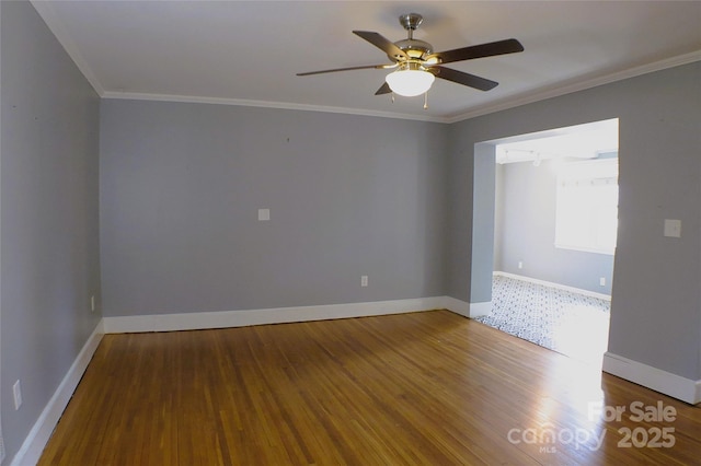 spare room featuring baseboards, ornamental molding, ceiling fan, and wood finished floors