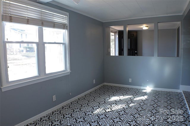 spare room with baseboards, ornamental molding, and a wealth of natural light