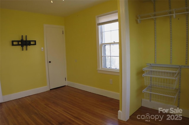 interior space with baseboards and wood finished floors