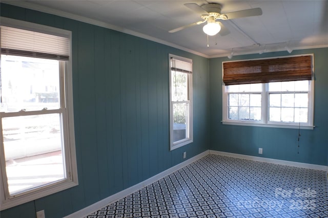 empty room with baseboards, a ceiling fan, and crown molding