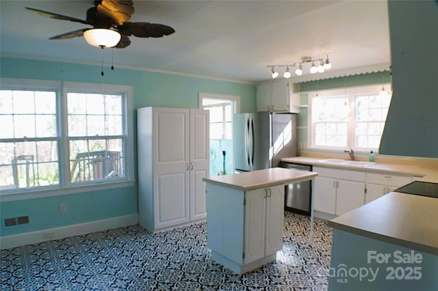 kitchen featuring a center island, stainless steel appliances, visible vents, a sink, and baseboards