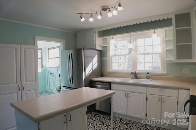 kitchen with stainless steel appliances, white cabinetry, a sink, and ornamental molding