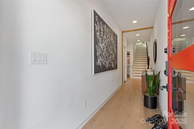 hall with stairway, recessed lighting, light wood-style flooring, and baseboards