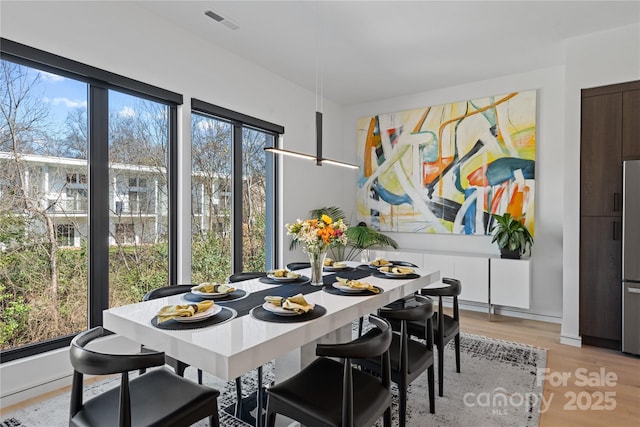 dining room with light wood-type flooring and visible vents