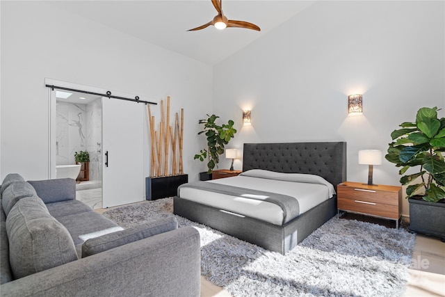 bedroom with ensuite bathroom, high vaulted ceiling, and a ceiling fan