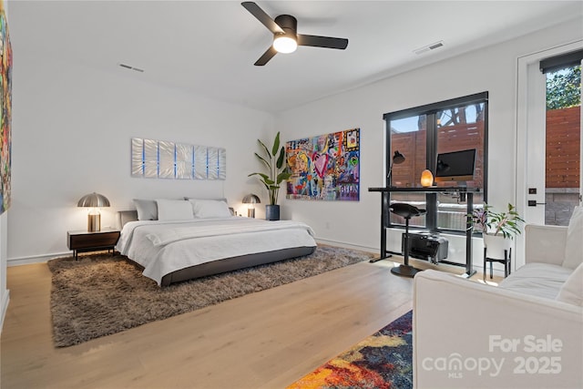 bedroom with wood finished floors, visible vents, and baseboards