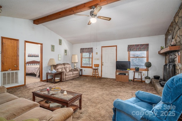 living area featuring visible vents, a ceiling fan, vaulted ceiling with beams, carpet, and a textured ceiling