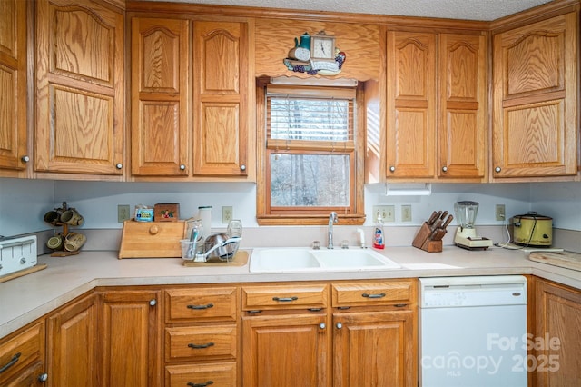 kitchen with dishwasher, light countertops, brown cabinetry, and a sink