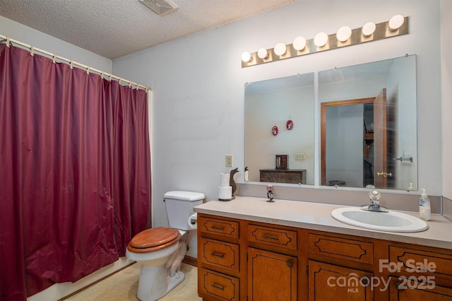 bathroom with visible vents, toilet, a shower with curtain, a textured ceiling, and vanity