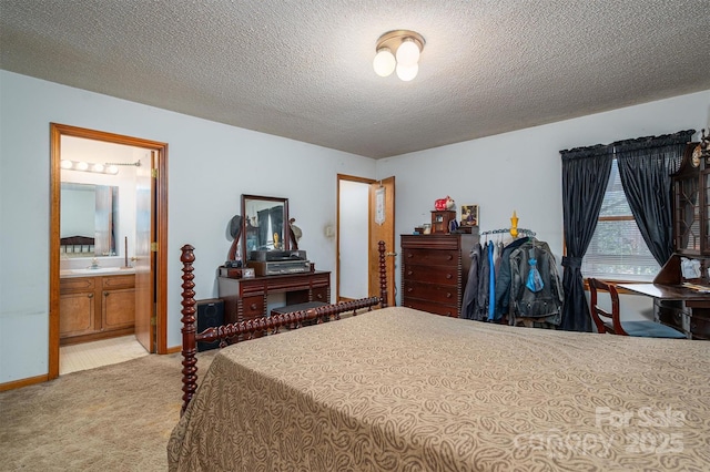 bedroom featuring light carpet, a sink, connected bathroom, a textured ceiling, and baseboards