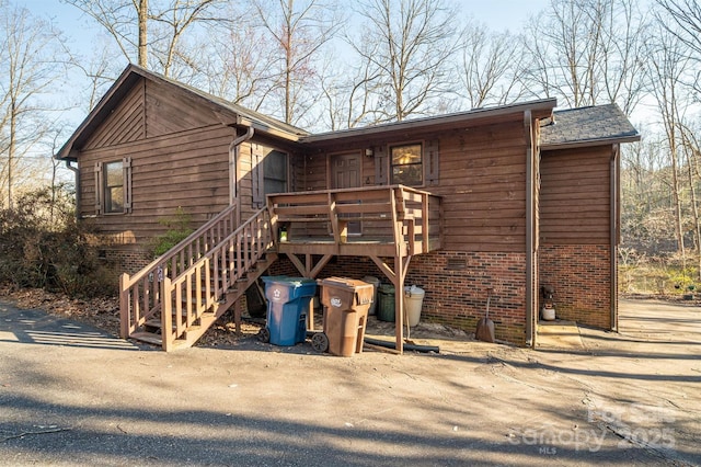 view of front of house with crawl space, stairway, and a wooden deck