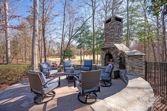 view of patio / terrace with an outdoor stone fireplace and fence