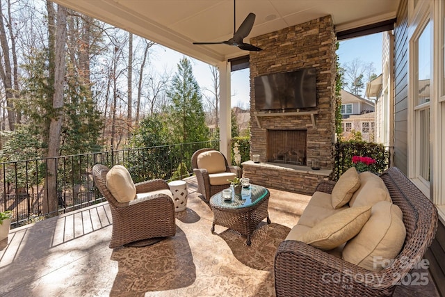 view of patio / terrace with a ceiling fan, an outdoor stone fireplace, and fence