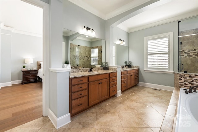 full bathroom featuring a garden tub, ornamental molding, a stall shower, vanity, and tile patterned flooring