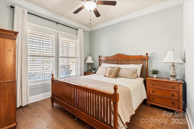 bedroom with baseboards, dark wood-type flooring, a ceiling fan, and crown molding