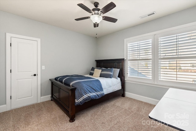 bedroom with baseboards, visible vents, a ceiling fan, and light colored carpet