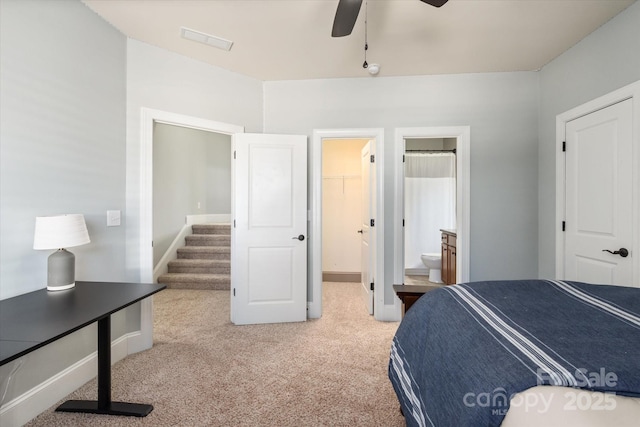 bedroom with baseboards, visible vents, connected bathroom, carpet, and a spacious closet