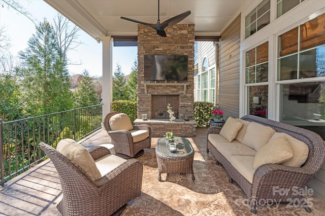 view of patio featuring an outdoor living space with a fireplace and ceiling fan