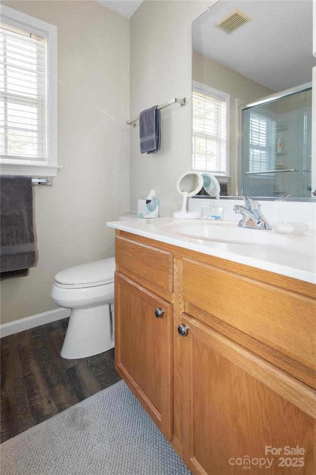 full bathroom with toilet, wood finished floors, vanity, visible vents, and a shower stall