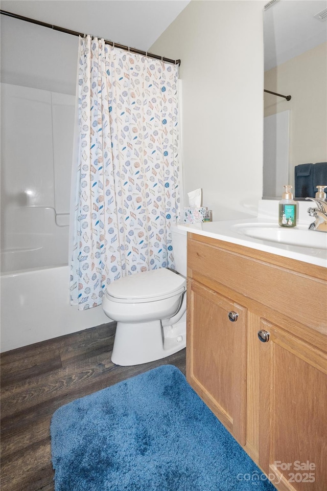 full bath with visible vents, toilet, shower / tub combo with curtain, wood finished floors, and vanity