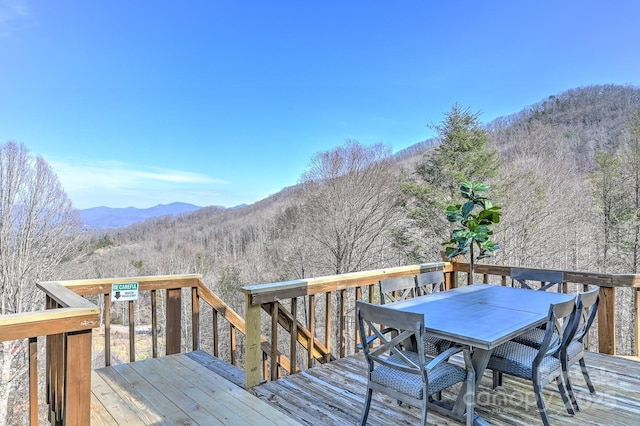 wooden terrace featuring outdoor dining area and a mountain view