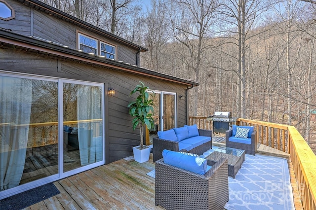 wooden terrace featuring a grill and an outdoor hangout area