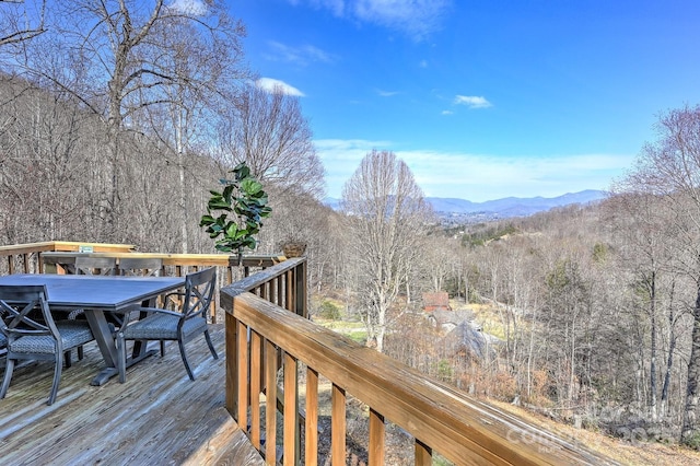 wooden deck featuring a mountain view and outdoor dining space