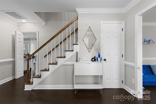 foyer with ornamental molding, visible vents, stairway, and wood finished floors