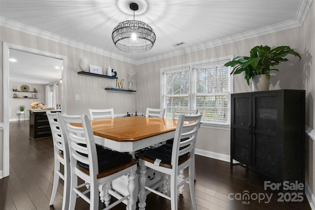 dining space with ornamental molding, visible vents, baseboards, and hardwood / wood-style flooring