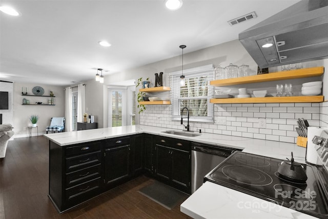 kitchen featuring visible vents, dishwashing machine, dark cabinets, open shelves, and a sink