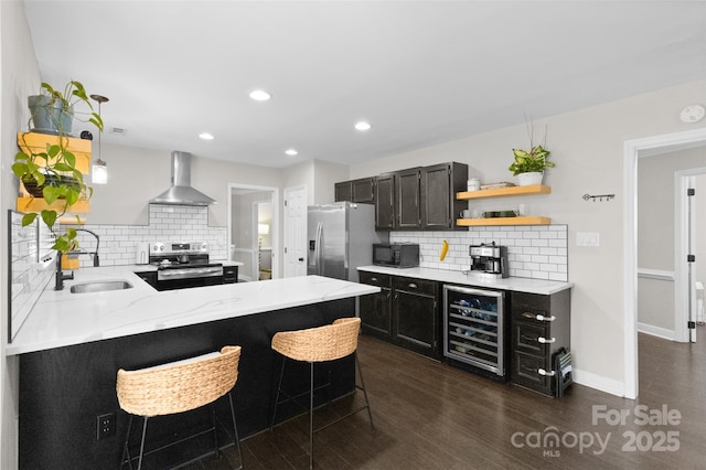 kitchen featuring open shelves, appliances with stainless steel finishes, a sink, beverage cooler, and wall chimney exhaust hood