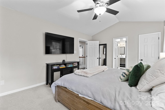 carpeted bedroom with lofted ceiling, ceiling fan, ensuite bath, and baseboards