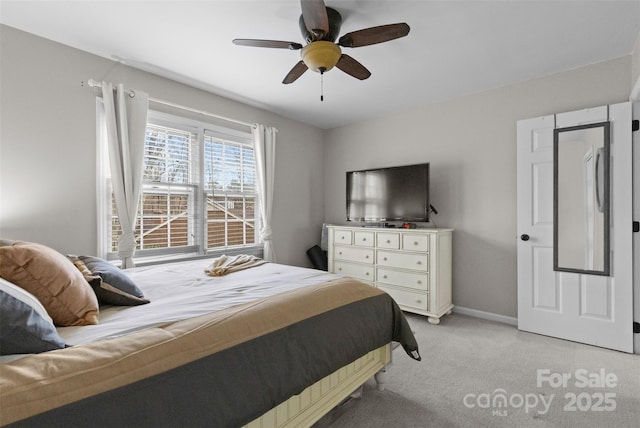 bedroom with light colored carpet, ceiling fan, and baseboards