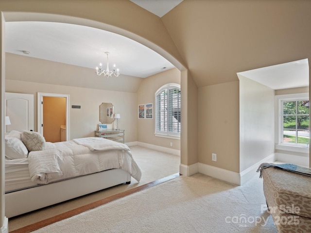 bedroom with a chandelier, lofted ceiling, light colored carpet, and baseboards