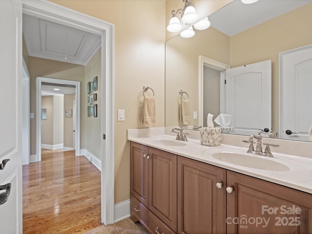 bathroom featuring double vanity, baseboards, a sink, and wood finished floors