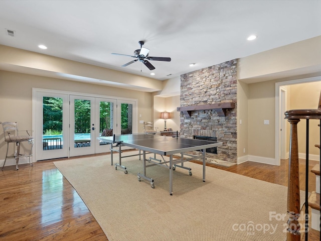 recreation room featuring a fireplace, visible vents, baseboards, french doors, and light wood finished floors