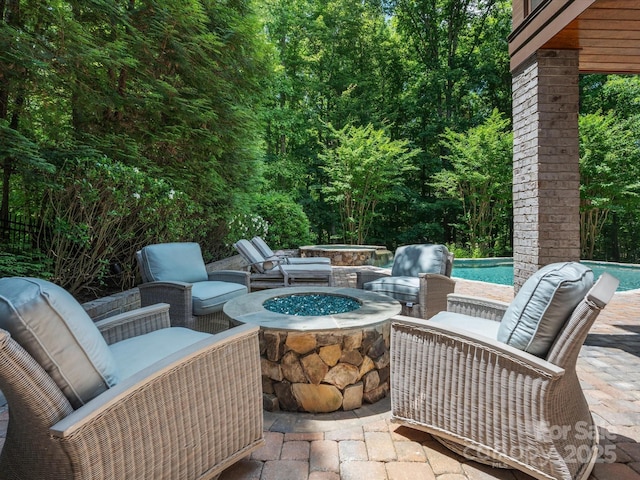 view of patio featuring an outdoor pool and a fire pit