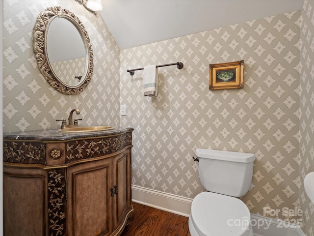 bathroom featuring toilet, wood finished floors, vanity, and baseboards