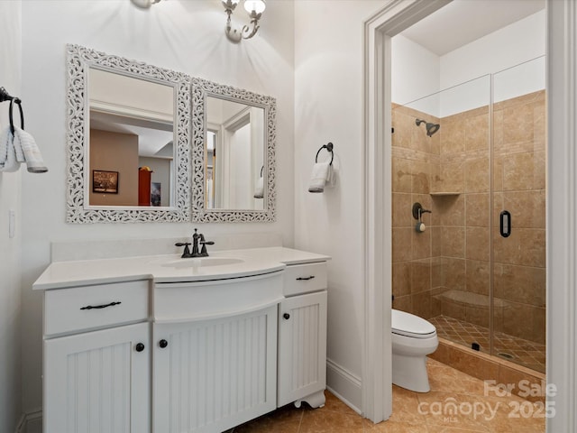 bathroom with toilet, a shower stall, vanity, tile patterned flooring, and baseboards