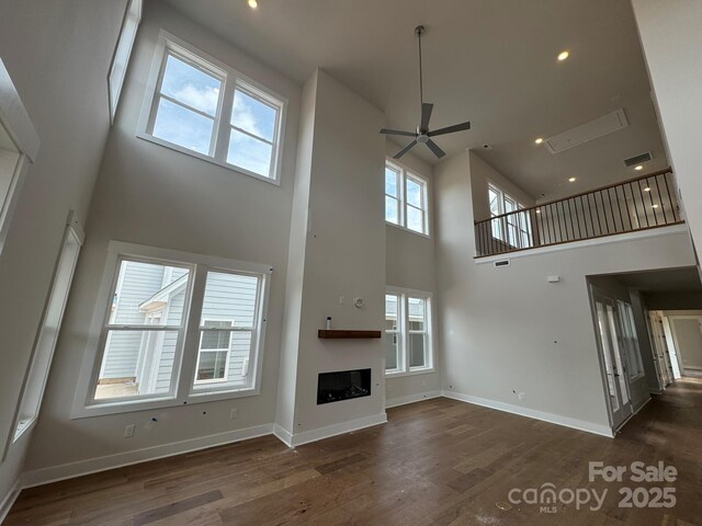 7441 Fighting Creek Rd Unit 30, Sherrills Ford, NC 28673 - unfurnished living room featuring a towering ceiling, wood finished floors, a ceiling fan, a fireplace, and recessed lighting