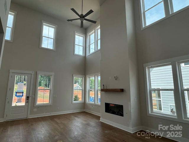 7441 Fighting Creek Rd Unit 30, Sherrills Ford, NC 28673 - unfurnished living room featuring a high ceiling, ceiling fan, dark wood-style floors, a glass covered fireplace, and plenty of natural light