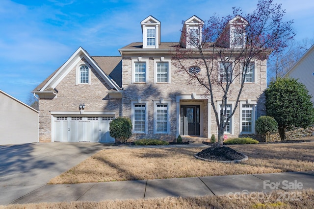 view of front of property with an attached garage, concrete driveway, and brick siding