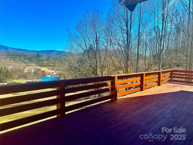 wooden terrace featuring a mountain view and a wooded view